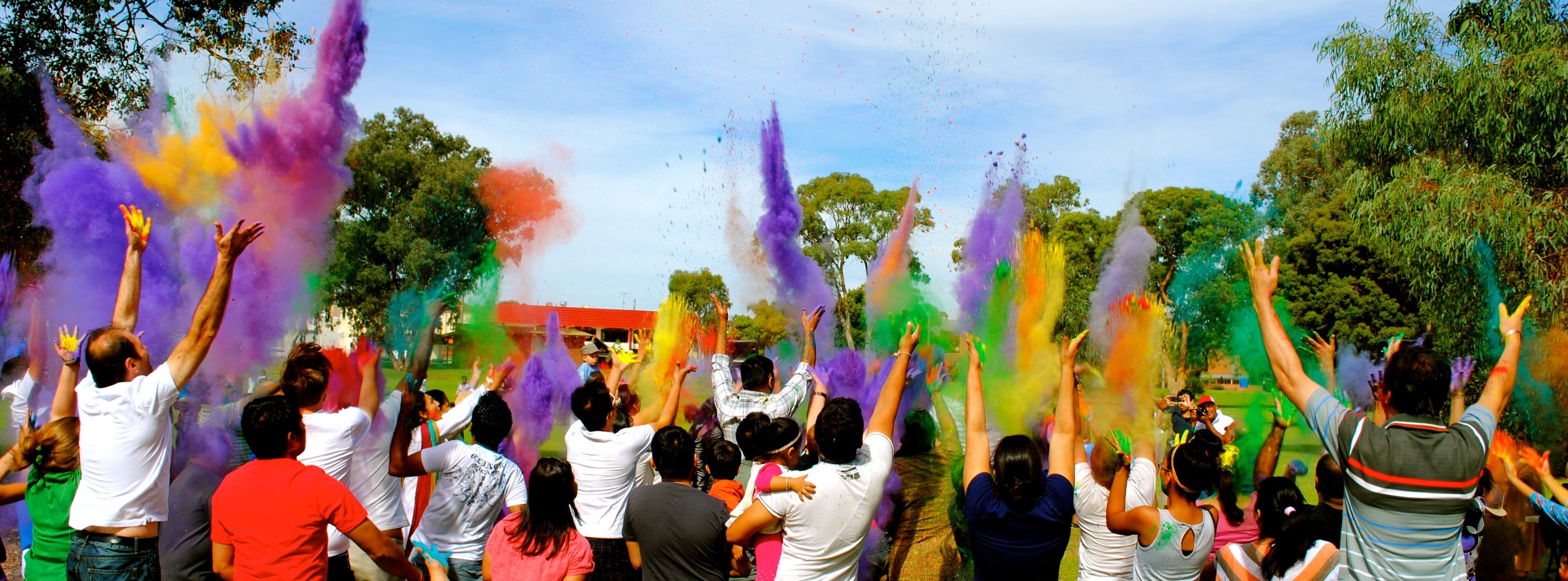 Community celebrating Holi and throwing colourful powder paint